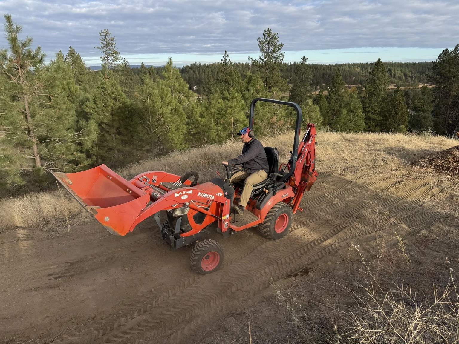 Two Vets Siteworks operator driving a tractor across a dirt work area